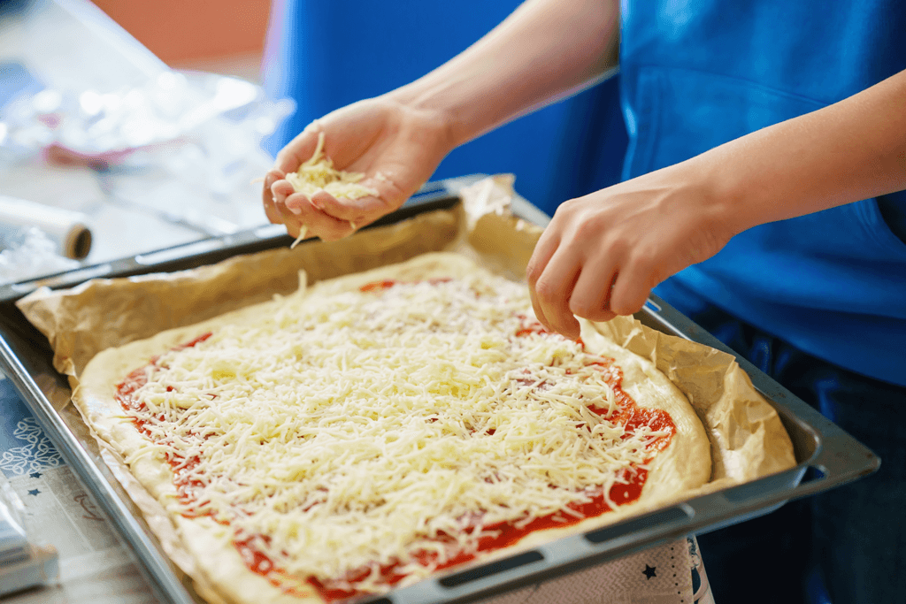 imagem de criança preparando uma pizza com mozzarella
